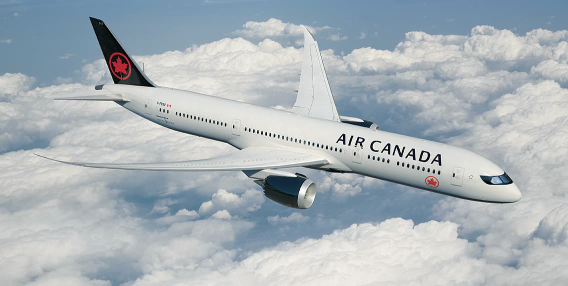 An Air Canada airplane soaring above the clouds.