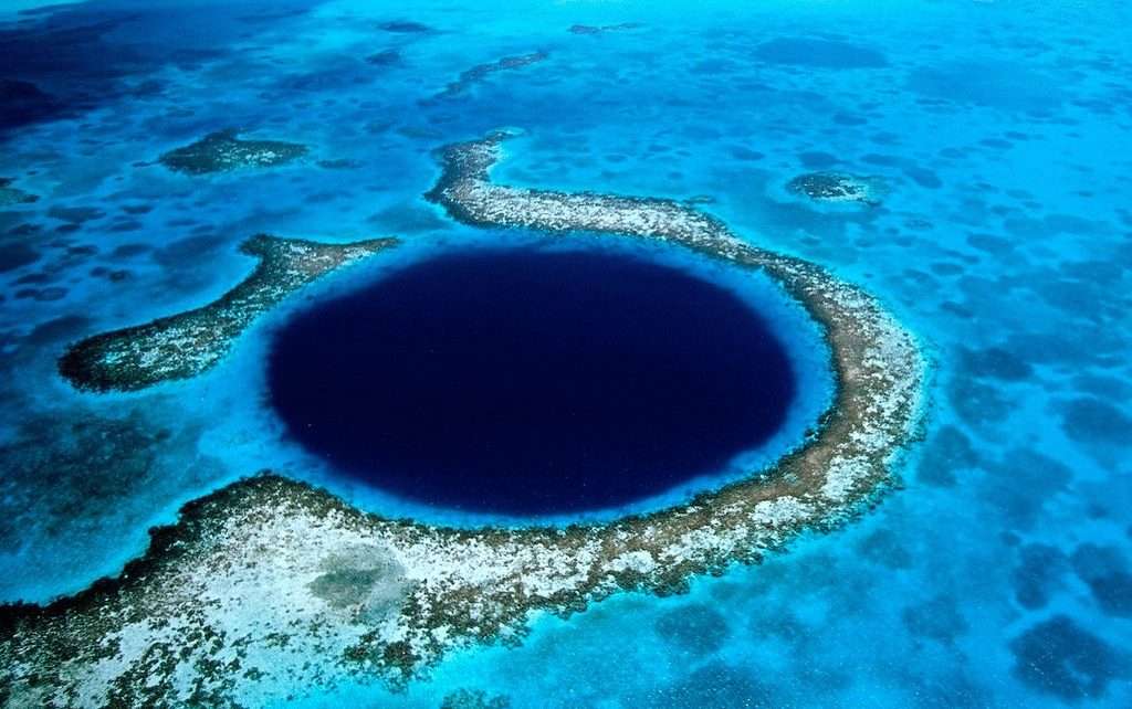 Aerial view of the Great Blue Hole surrounded by turquoise water and coral reefs.