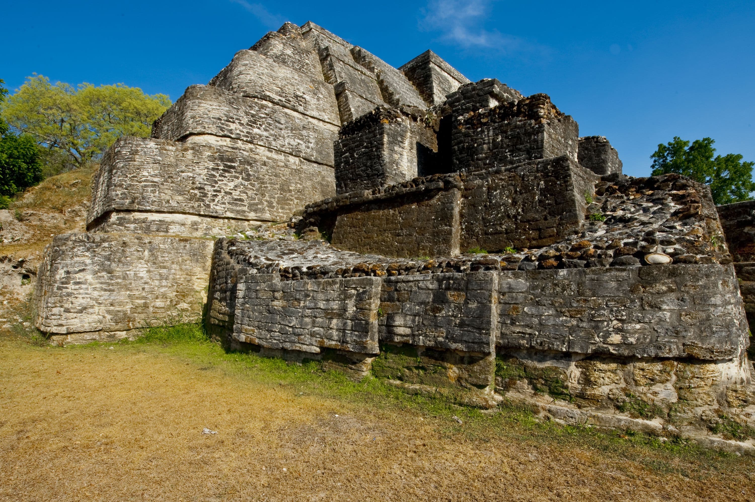 Ancient stone pyramid structure with grassy surrounding.