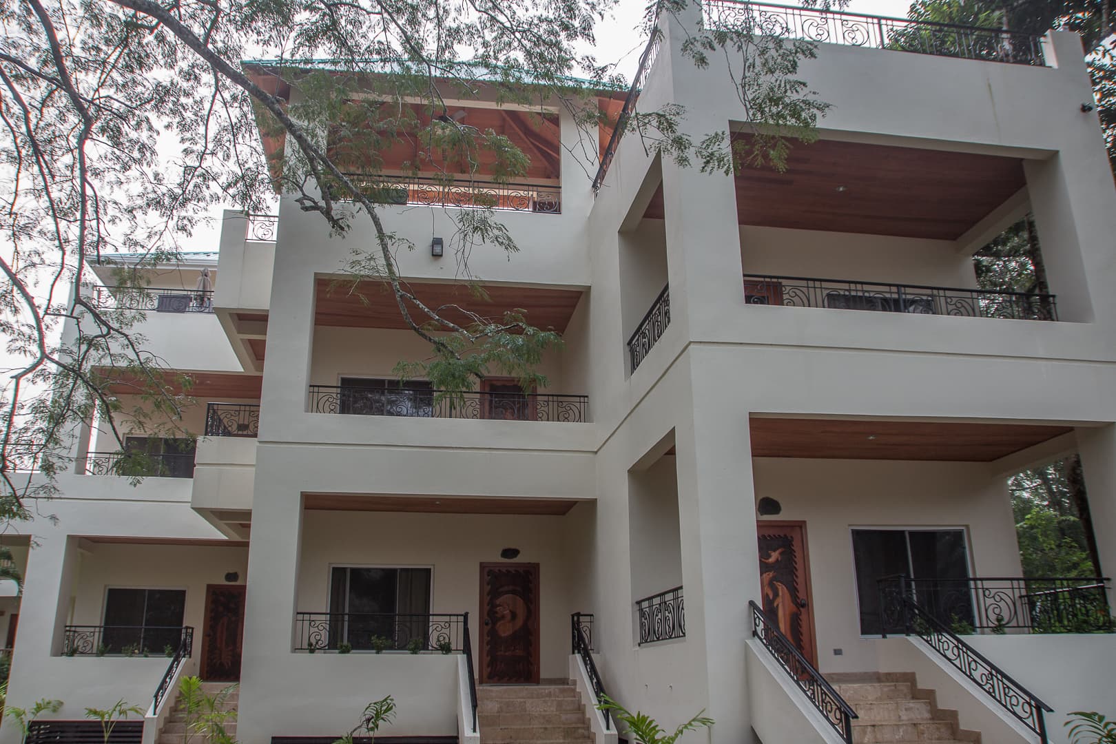 Three-story modern building with balconies and wooden accents.