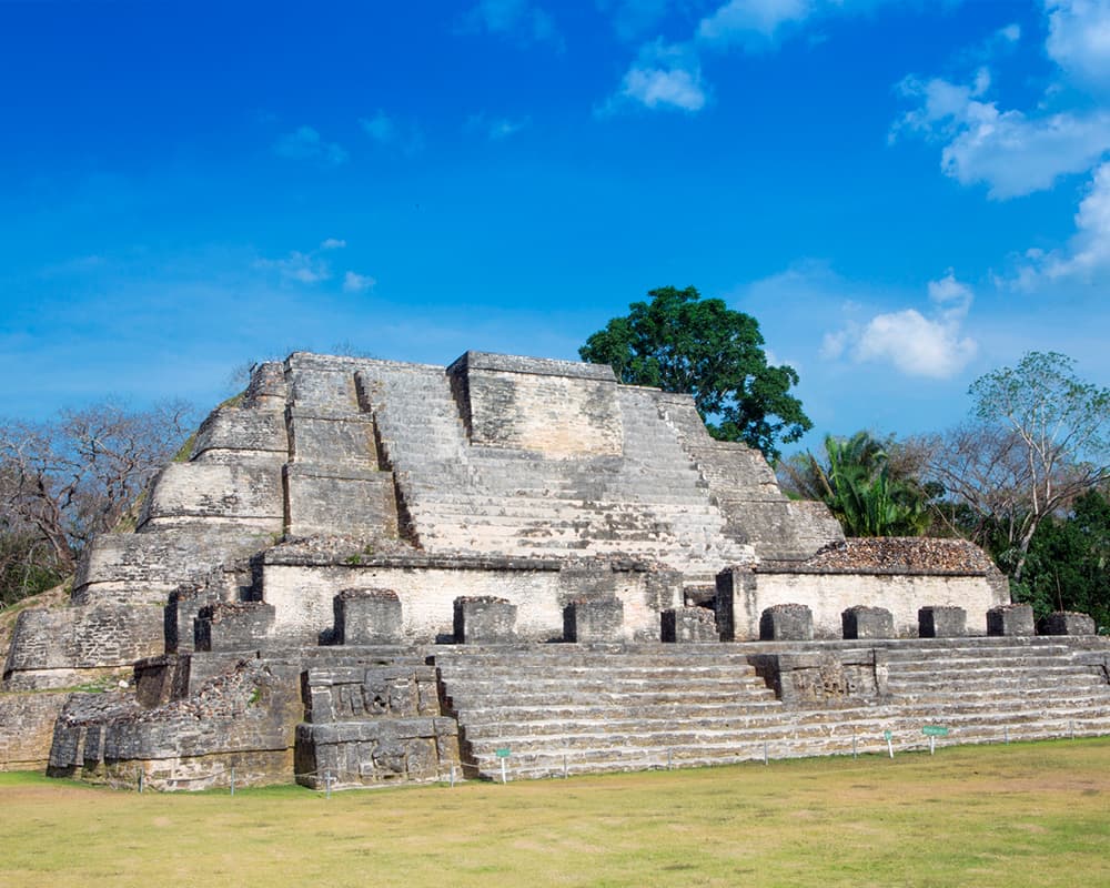 Ancient Mayan pyramid set against a bright blue sky.