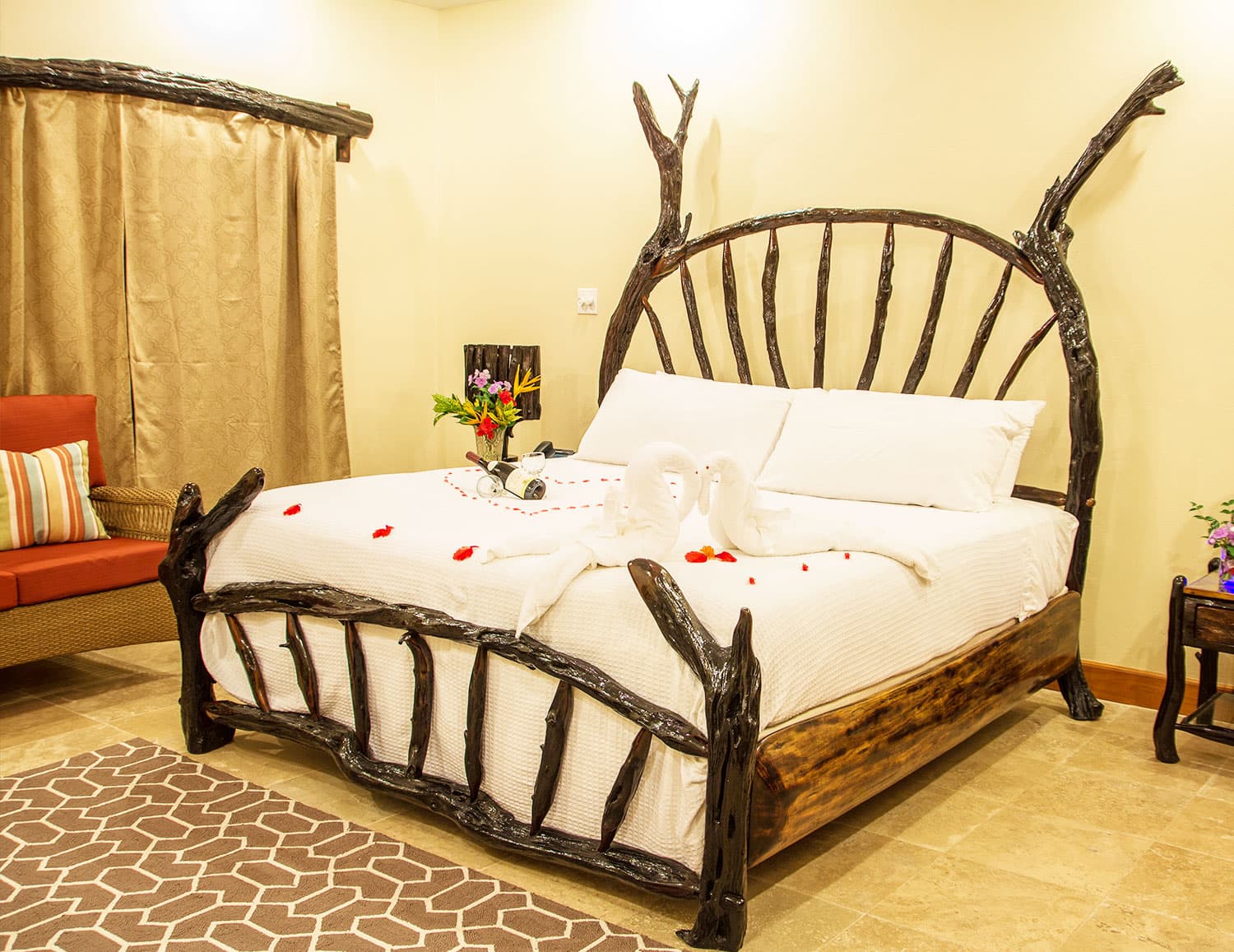A cozy bedroom featuring a unique wooden bed frame and decorative flowers.