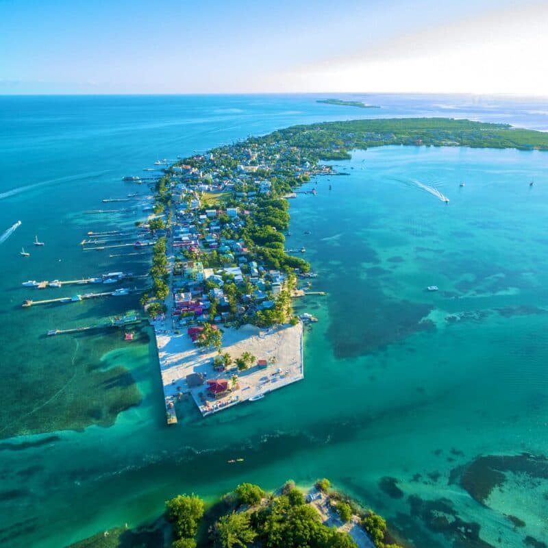 Aerial view of a tropical island with colorful houses and clear turquoise waters.