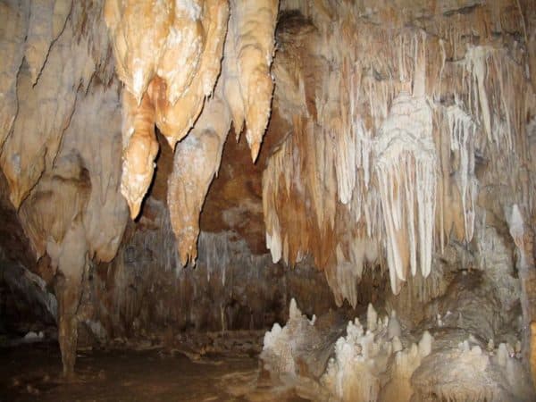 Stalactites and stalagmites in a scenic cave interior.